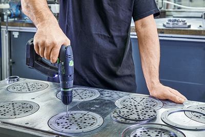 En hantverkare bearbetar slipplattor av metall