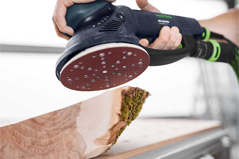 En träbit slipas med en Rotex-slipmaskin och lämpligt Rubin-slippapper