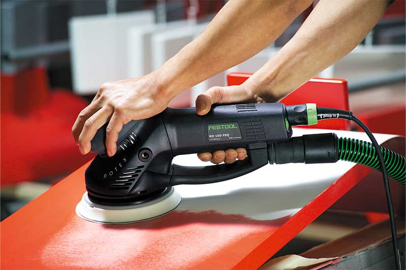 En röd yta slipas med en Rotex-slipmaskin