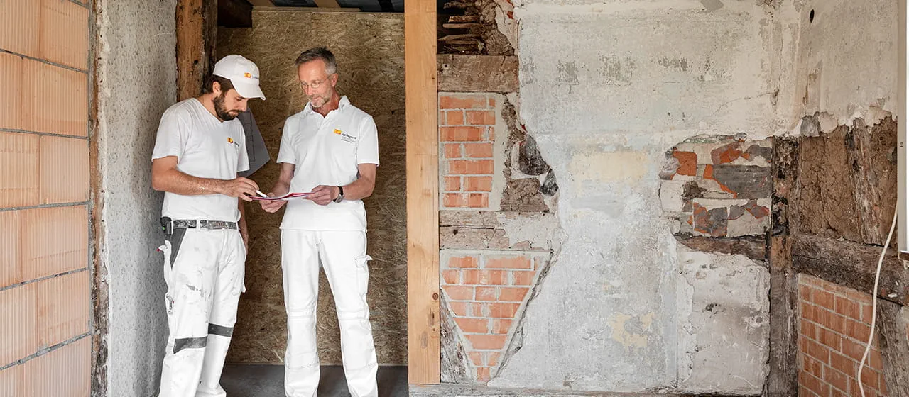 Målarmästaren och restauratören Manfred Schuler och hans medarbetare Marco Dworzak diskuterar nästa steg i renoveringen