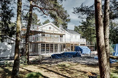 Utsikt över huset täckt av ställningar i den svenska skogen