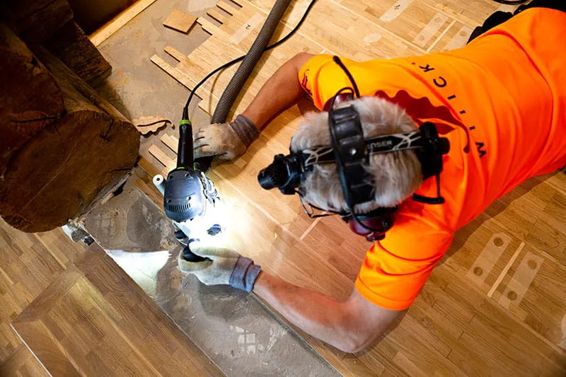 Den finska parkettläggaren bearbetar trägolvet med Festools handöverfräs