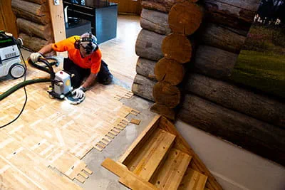 Den finska parkettläggaren bearbetar golvet med Festools handöverfräs