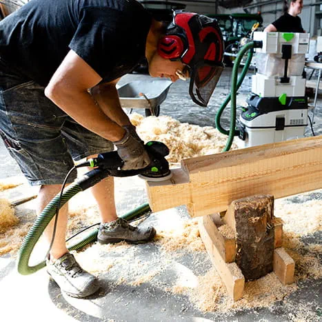 En bastubyggare slipar träytan med Rotex 150 från Festool.