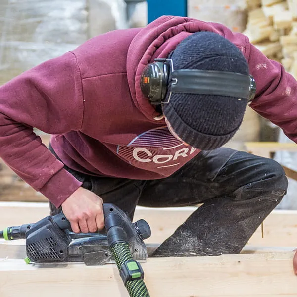 Träbalkarna hyvlas med Festools enhandshyvel