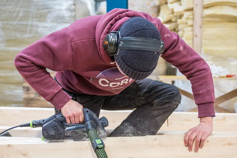 Träbalkarna hyvlas med Festools enhandshyvel